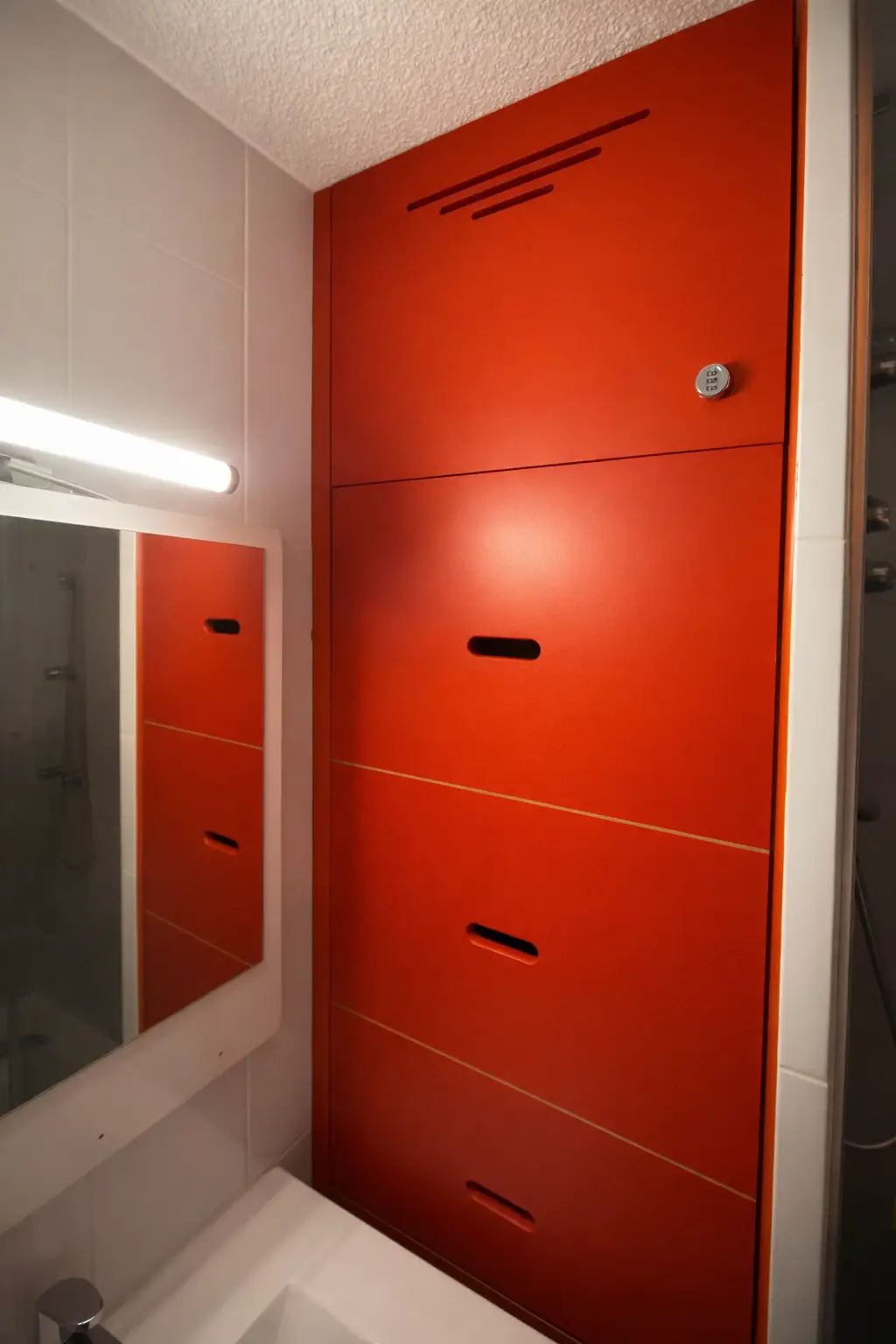 Meuble de rangement sur mesure en salle de bain, adapté à un espace contraint avec trappes, ventilation et finitions personnalisées