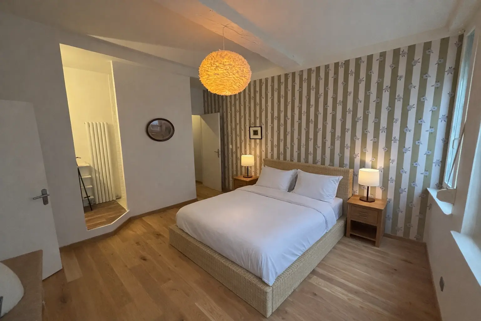 Chambre rénovée avec pose de papier peint, peinture murale, parquet bois et aménagement intérieur réalisé par un artisan